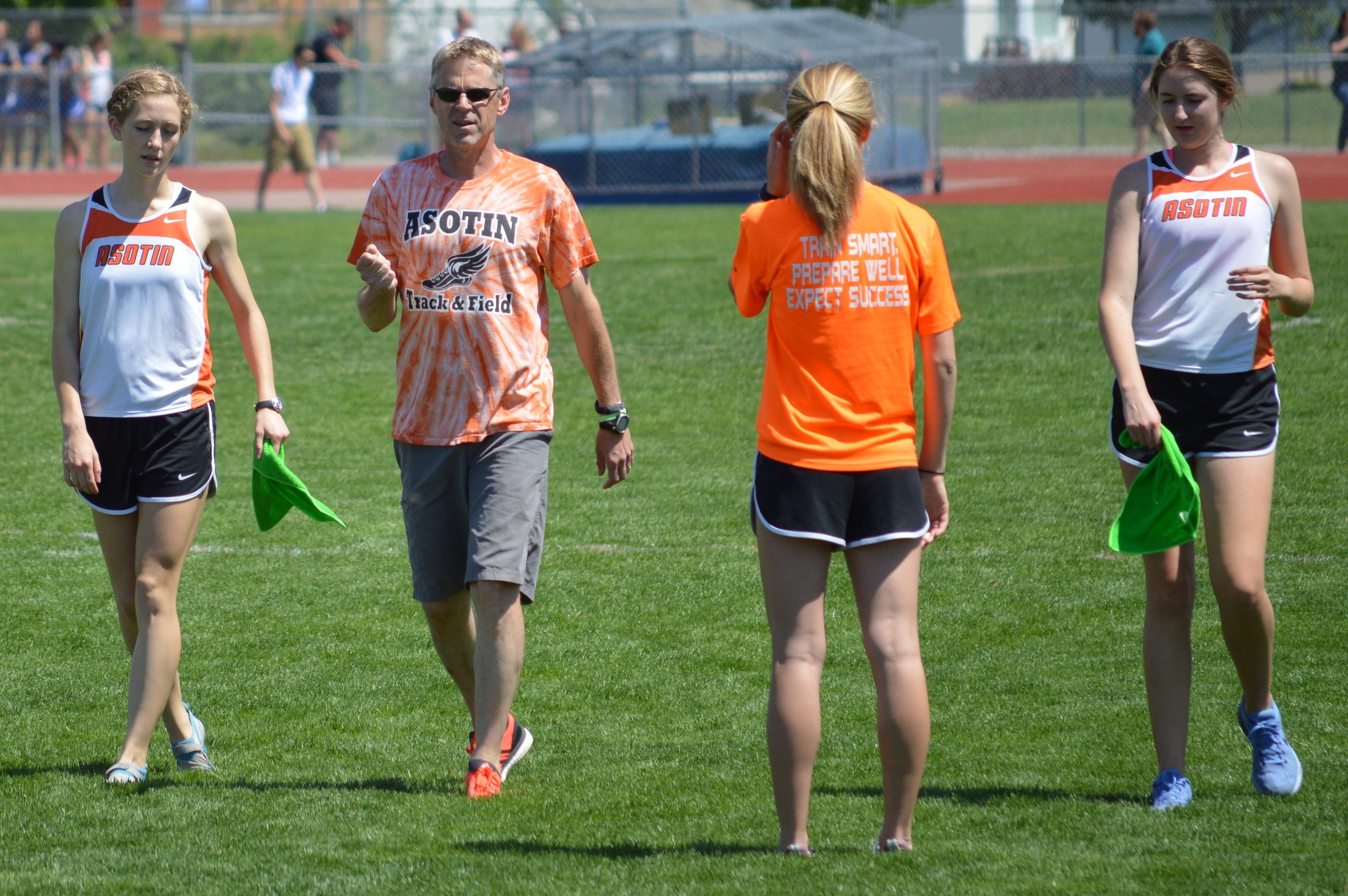 Coach Tim Gundy of Asotin with Lucy Eggleston (left), Maria Eggleston (with back turned), and Kat Stephenson.