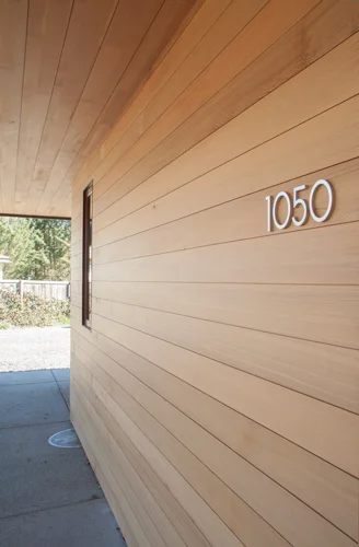 This house has reclaimed cedar siding and reclaimed Grandstand Fir soffit with a matte clear finish to protect the wood. The deep overhangs also provide shelter to extend the life of this installation.