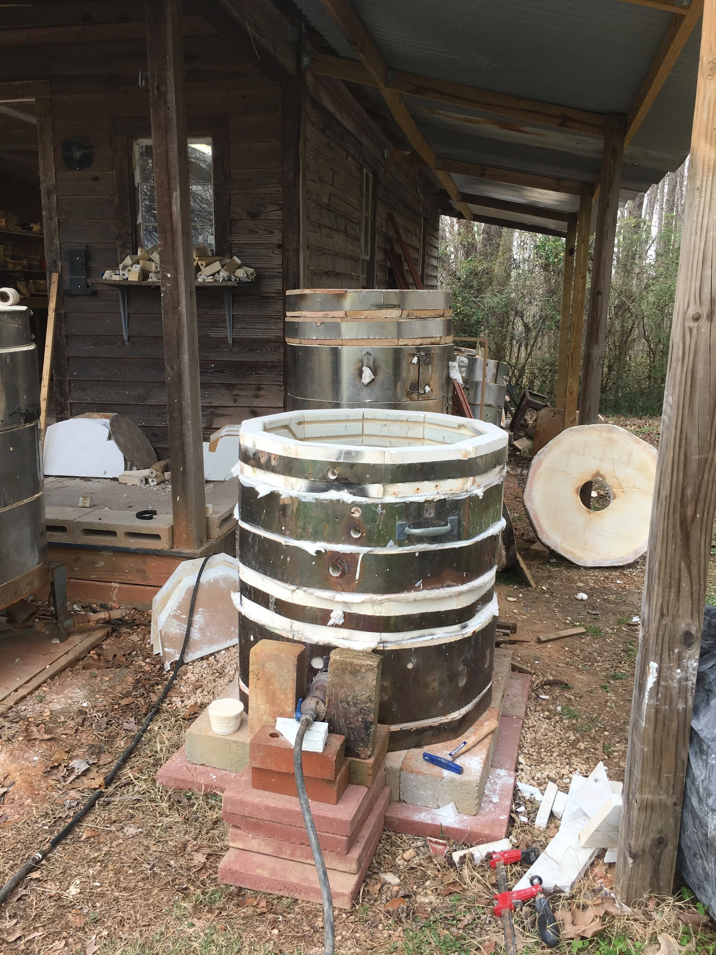 Jarad uses natural gas with a small single burner placed in front of the large opening drilled at the base of the kiln to fuel the kiln. 