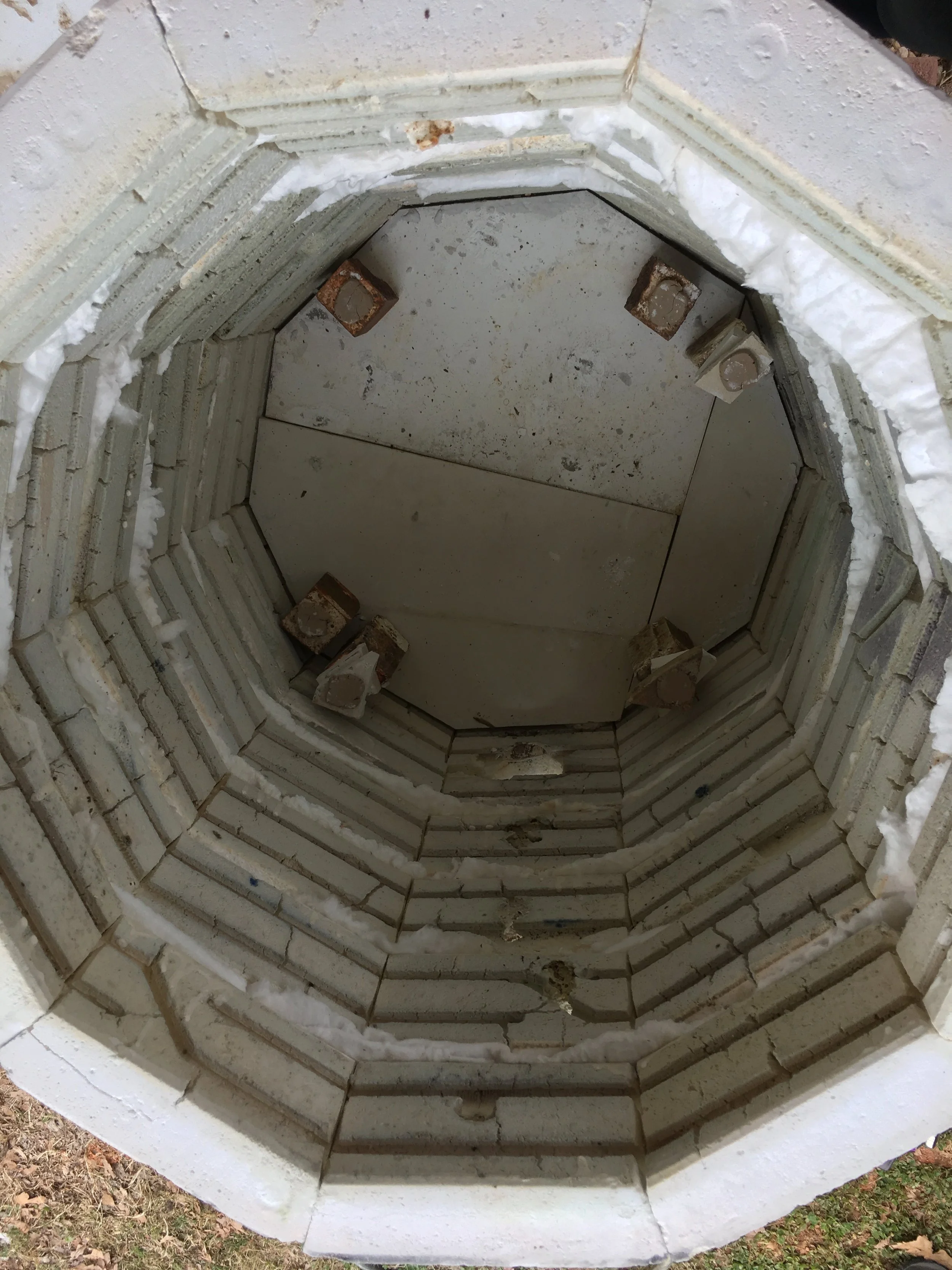 The interior of the kiln is coated with a layer of celadon base glaze, like kiln wash, which acts a protective barrier for the soft brick. No pots are loaded at the very bottom of the kiln. Jarad uses 4" and 6" posts to create a sort of fire box at the bottom of the kiln. The pots are then stacked and staggered up the create the load.