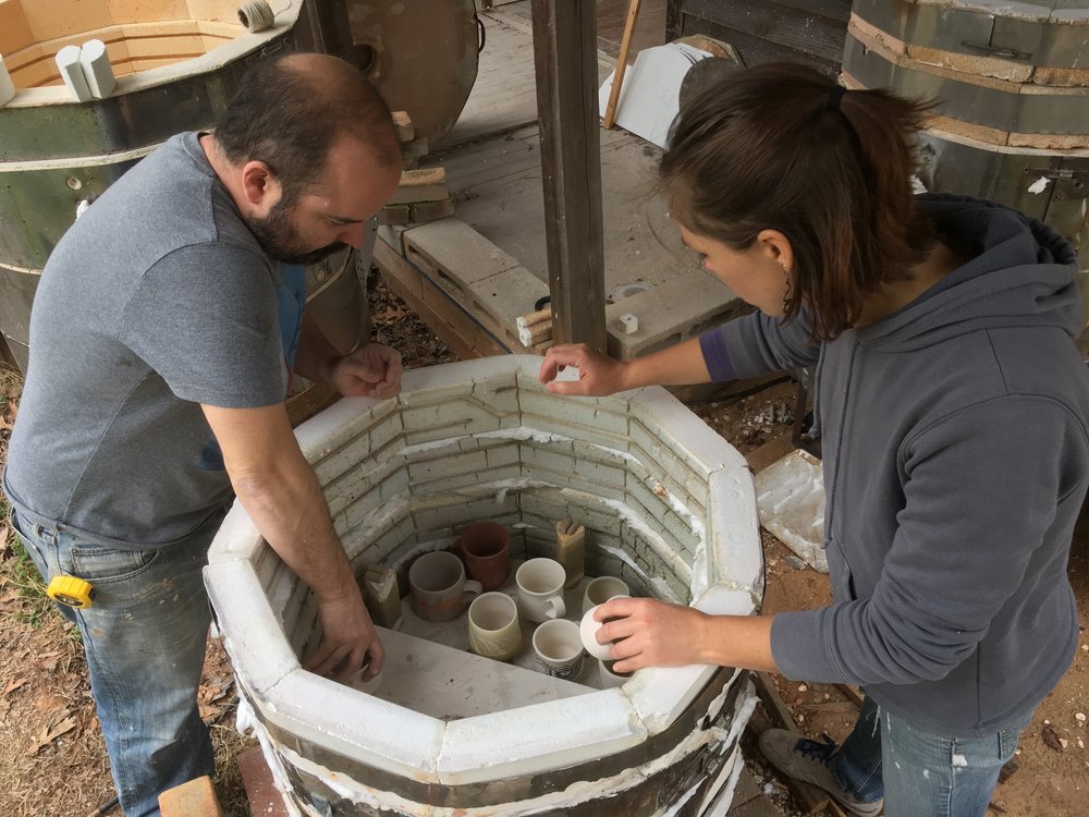  Jarad and Katie loading the kiln. &nbsp;The shelves and pots are staggered to help create a flow for the flame and soda. 