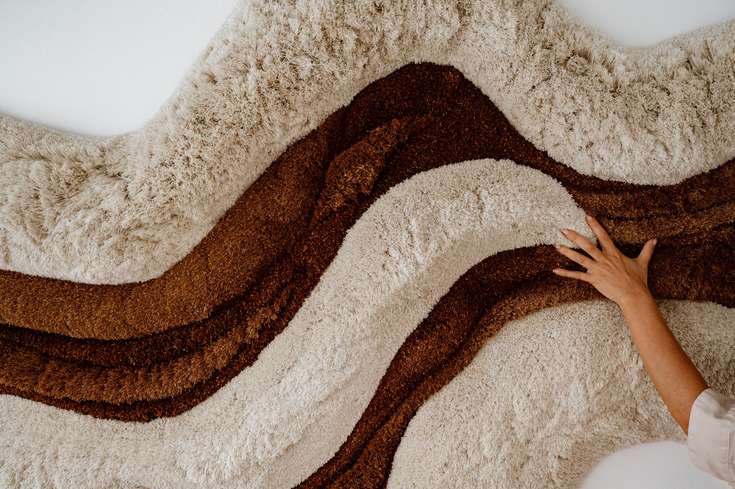 Detail of Flowing Waves textile art showing sculptural tufted textures and tonal transitions inspired by natural landscapes.