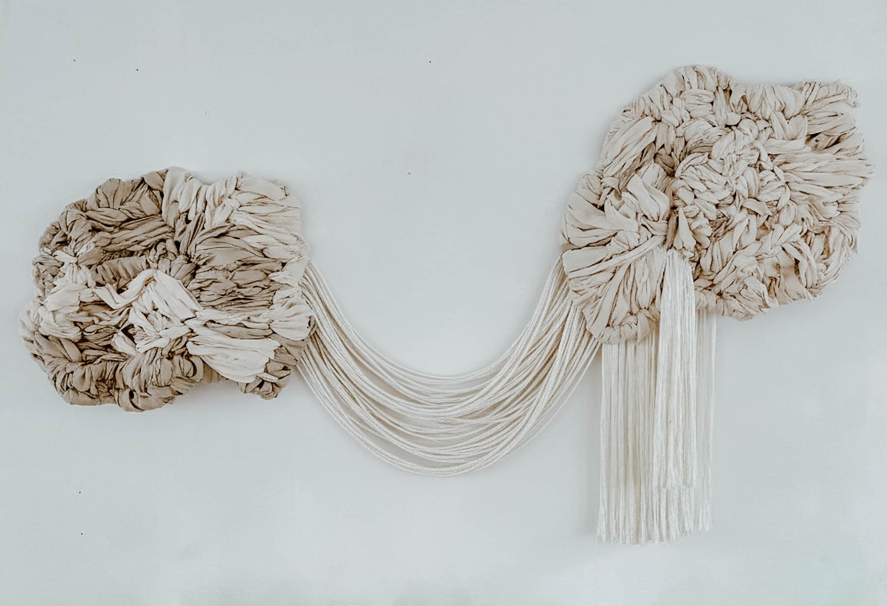 Hand-tufted contemporary textile wall sculpture with organic floating forms and soft fiber texture designed for interior architectural spaces.