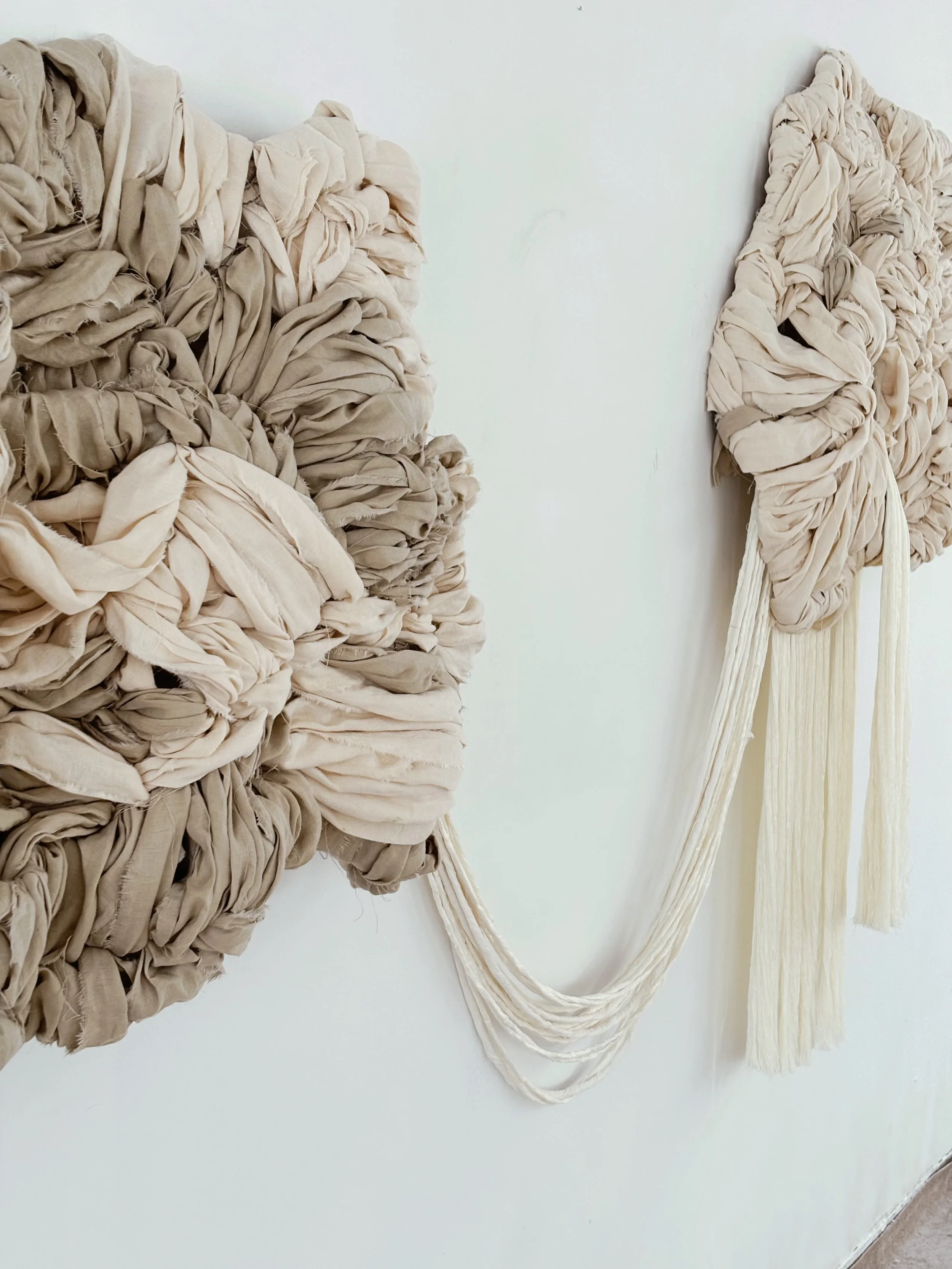 Hand-tufted contemporary textile wall sculpture with organic floating forms and soft fiber texture designed for interior architectural spaces.