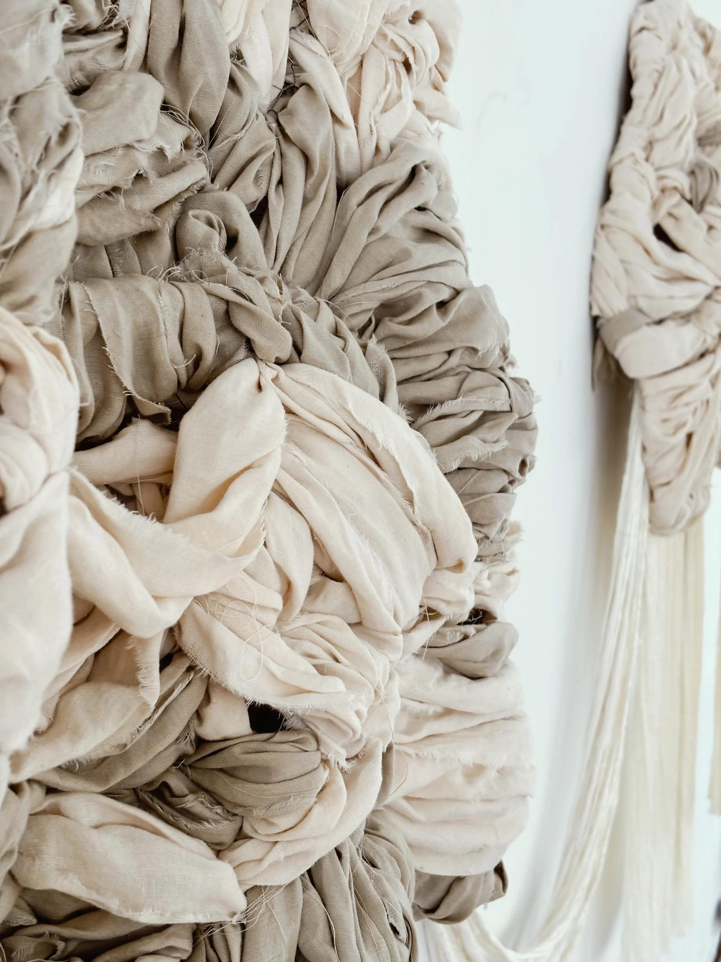 Hand-tufted contemporary textile wall sculpture with organic floating forms and soft fiber texture designed for interior architectural spaces.