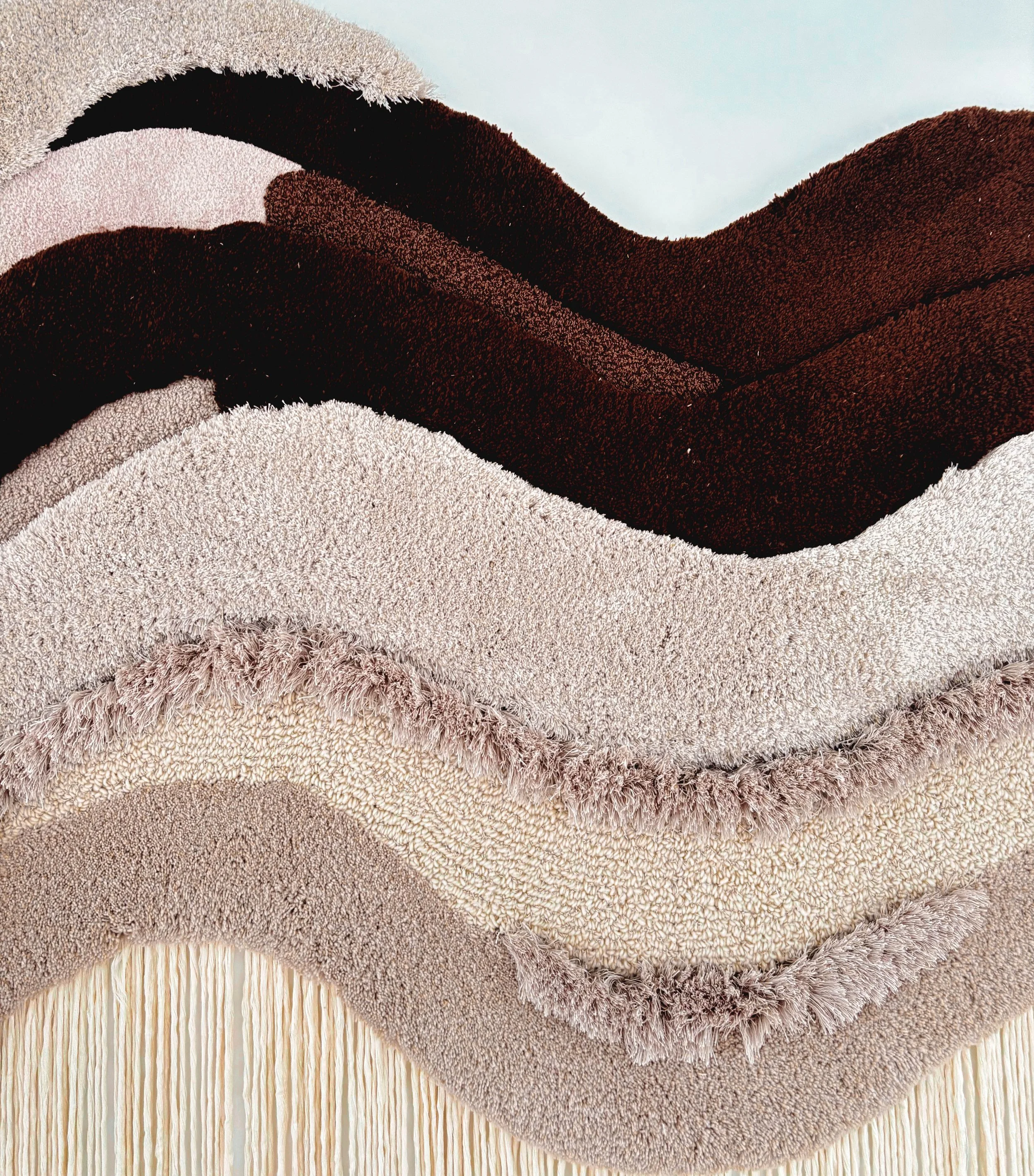 Close-up detail of handcrafted tufted textile artwork showing layered textures, soft wool fibers and natural beige and brown color palette. (Copy)