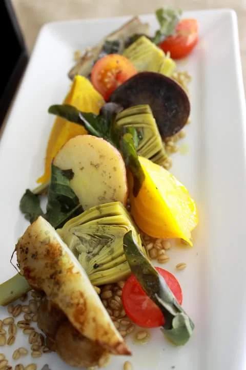 Enjoy roasted and raw vegetables in a salad with barley and red wine vinaigrette over fresh greens. 