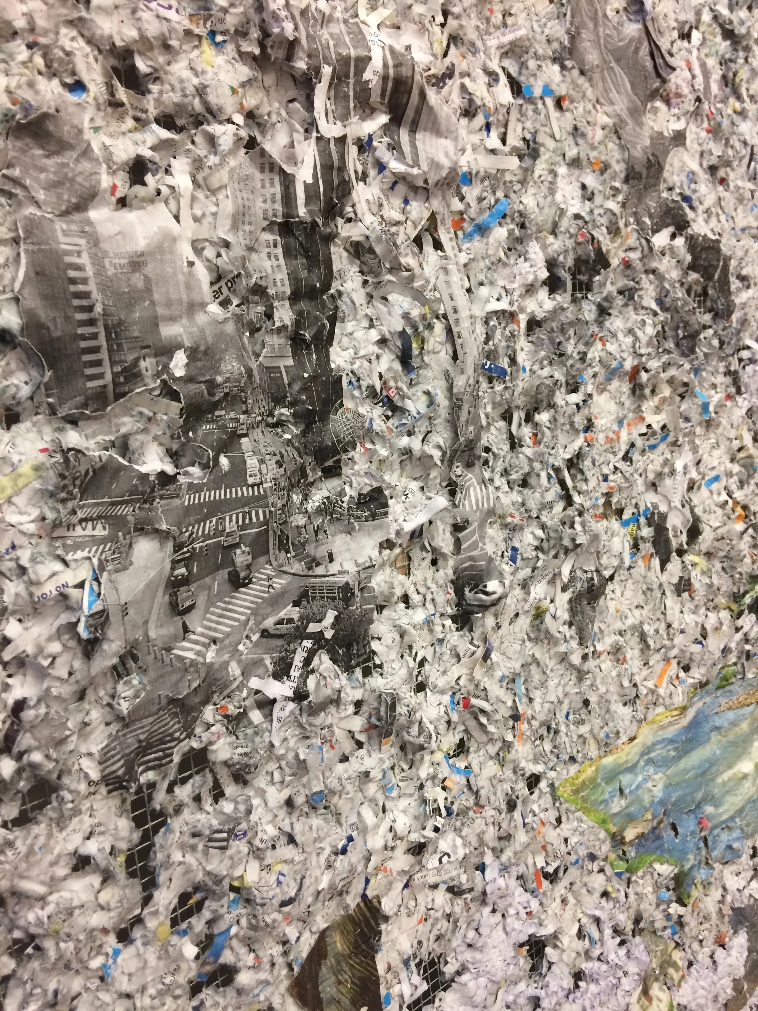 Landing (Mist Parts Over Columbus Circle) (detail), 2017, medical records, credit card offers, tiki decorations, nature calendars, plastic tablecloths, plastic bags, Dora the Explorer puzzle pieces, photo, maps and oil on chicken wire and wood, 48 x 66 x 4 inches