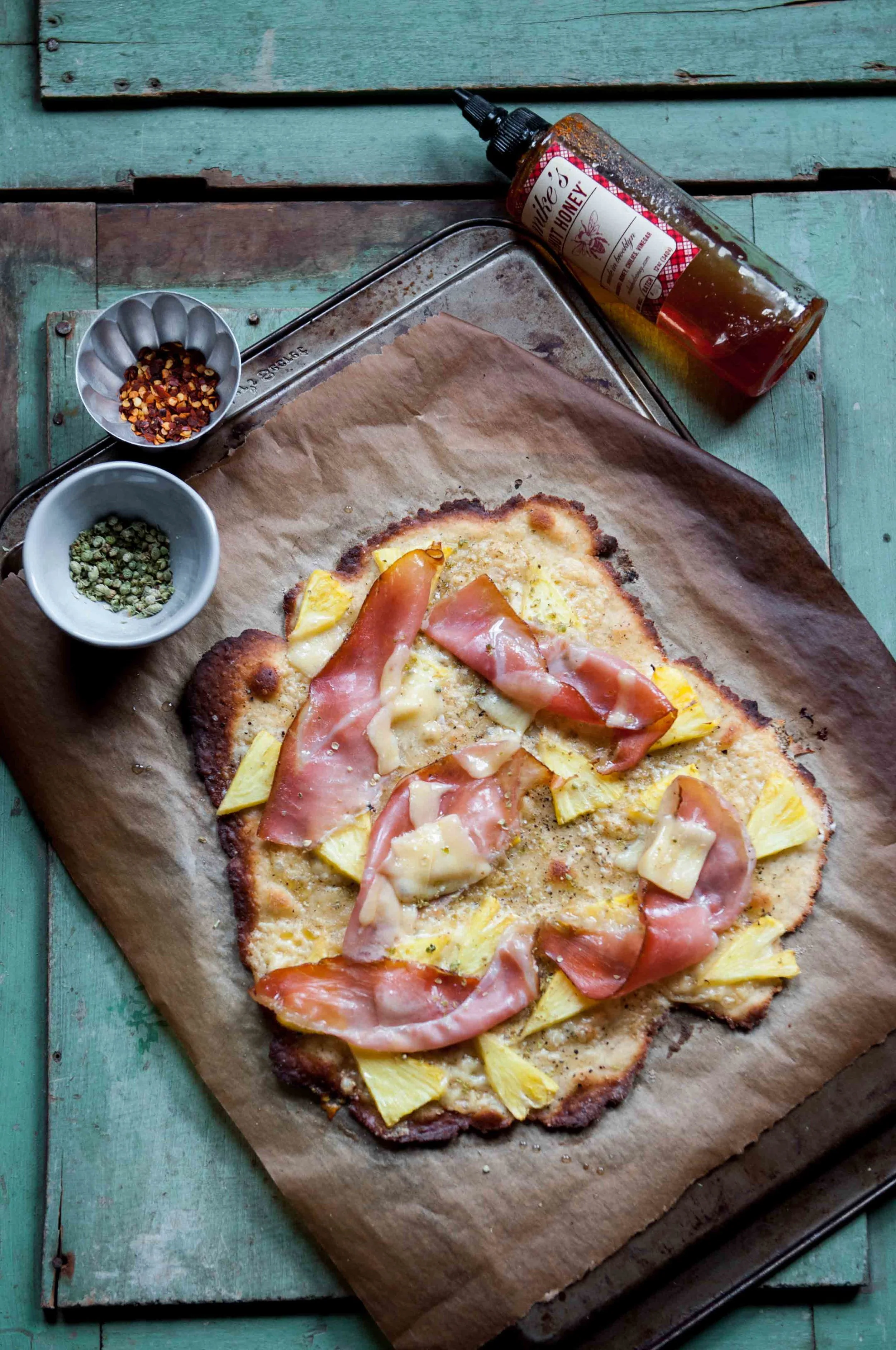 This gluten free crust is made with a blend of gluten free flour, boosted with psyllium husk for binding and incorporates yeast to lend the familiar earthy flavors of a pizza crust. Ham and pineapple are the staid cravings of comfort anywhere :)