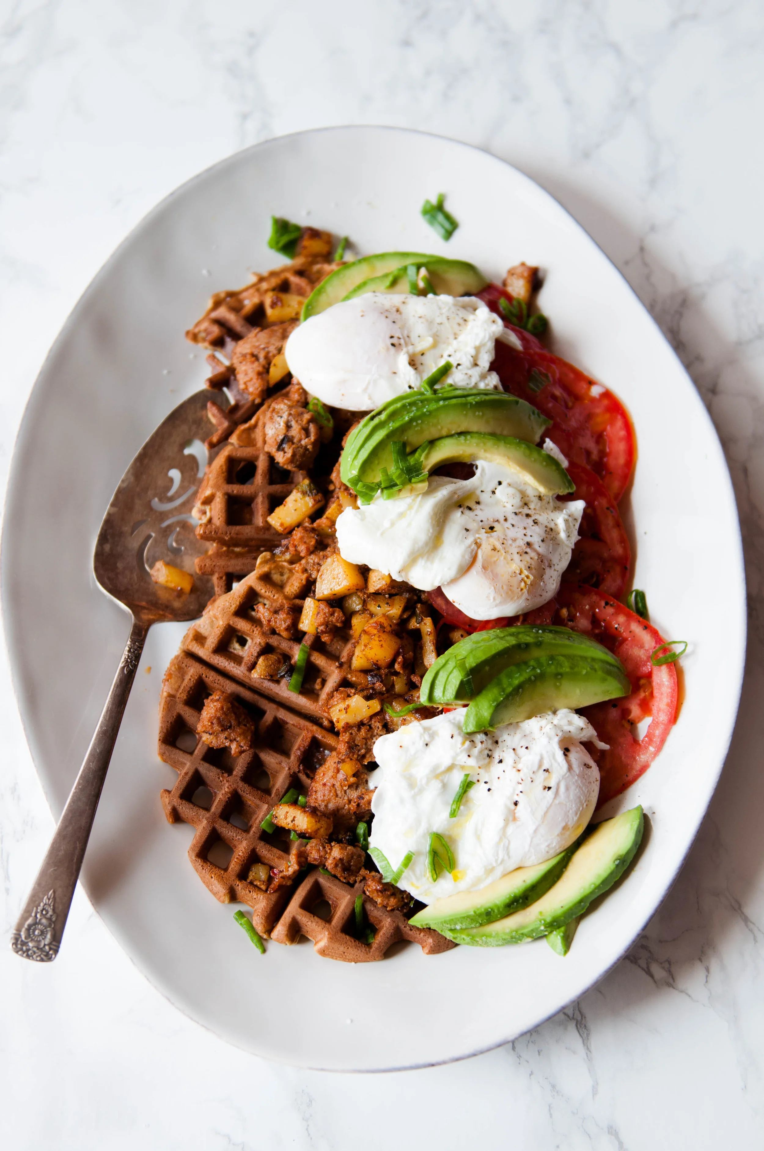 Chickpea and Einkorn Waffles with chorizo hash, poached eggs, sliced Summer tomatoes and avocado
