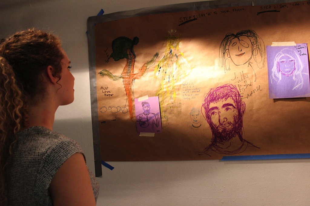Lili Boisrond '17 examines the club's portraits at the end of the party