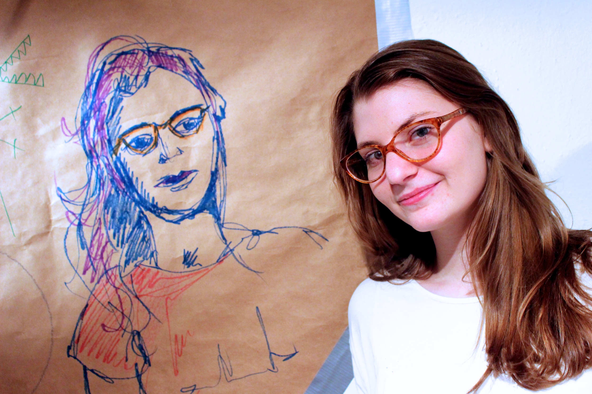  Lilly Rosner '14 poses next to a portrait done by Lili Boisrond '17 