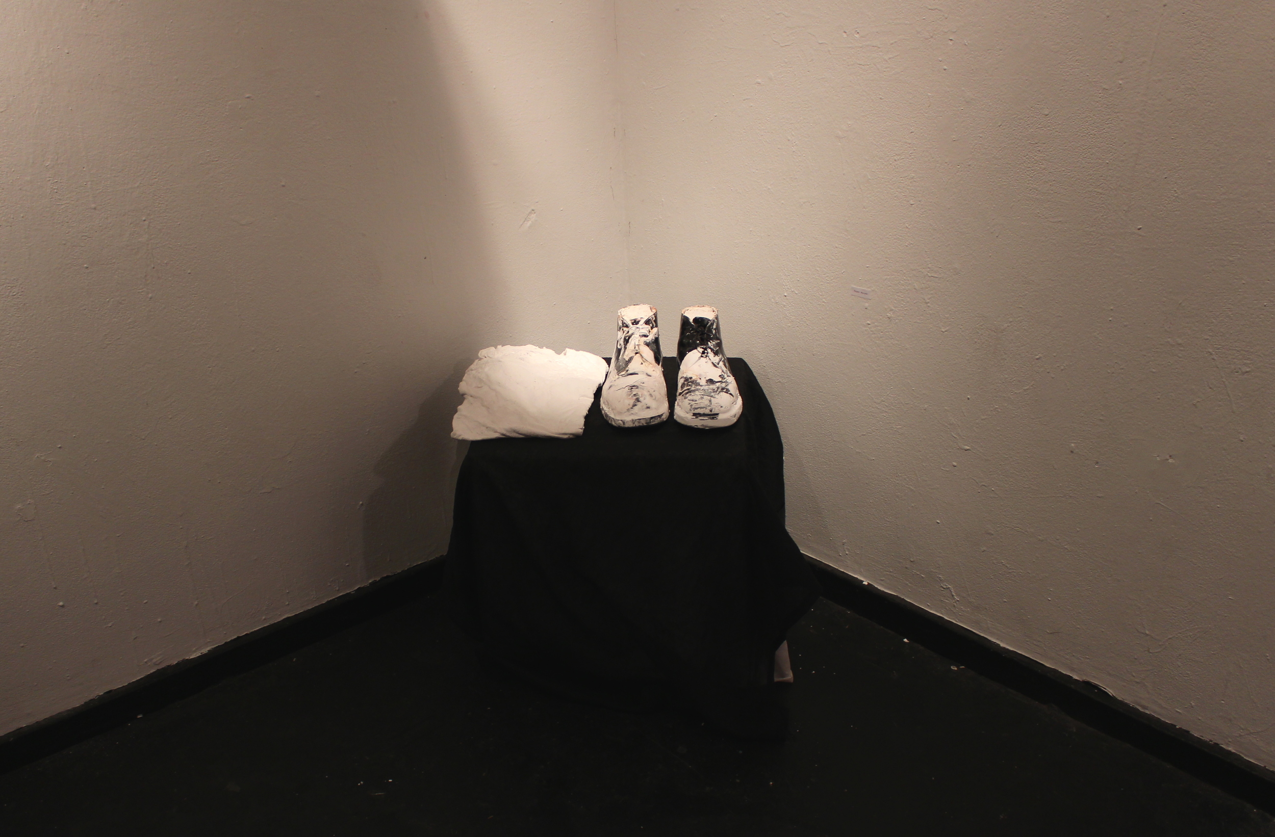  Cement filled shoes created by Tuyen Nguyen '17 quietly occupied a corner of the room. Photo by Lexie Brown '17  