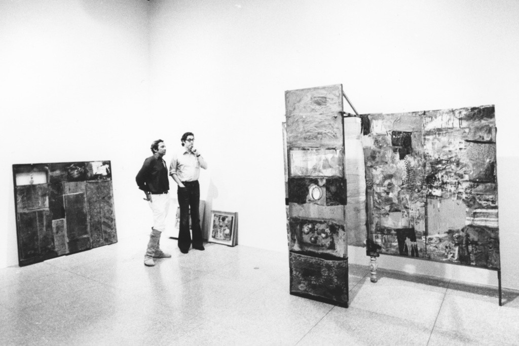 Rauschenberg and Walter Hopps discussing *Minutiae*(1954) during the installation of the retrospective exhibition *Robert Rauschenberg*, National Collection of Fine Arts, Smithsonian Institution, Washington, DC, 1976. Photo: Gianfranco Gorgoni via Artsy.net