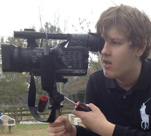 Blease posing with his camera as he shoots one of his films.