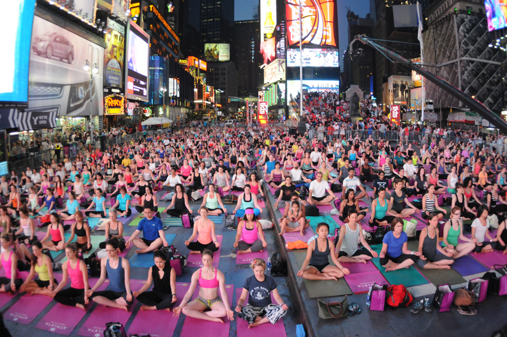 An ocean of yogis meditating after sunset at Solstice in Times Square