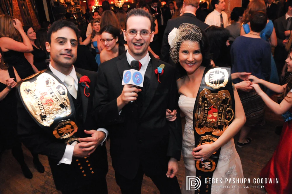 The bride and groom with their wrestling championship belts