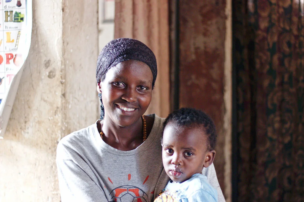Evelyn sits in her home with her youngest son, Mario.