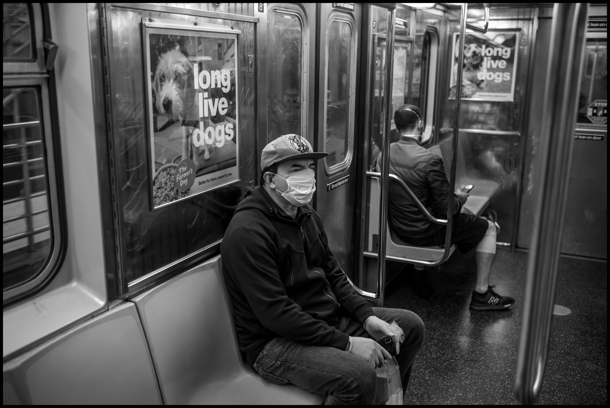  A masked man rides north on the #1 train.  March 21, 2020. © Peter Turnley.  ID# 01-017 