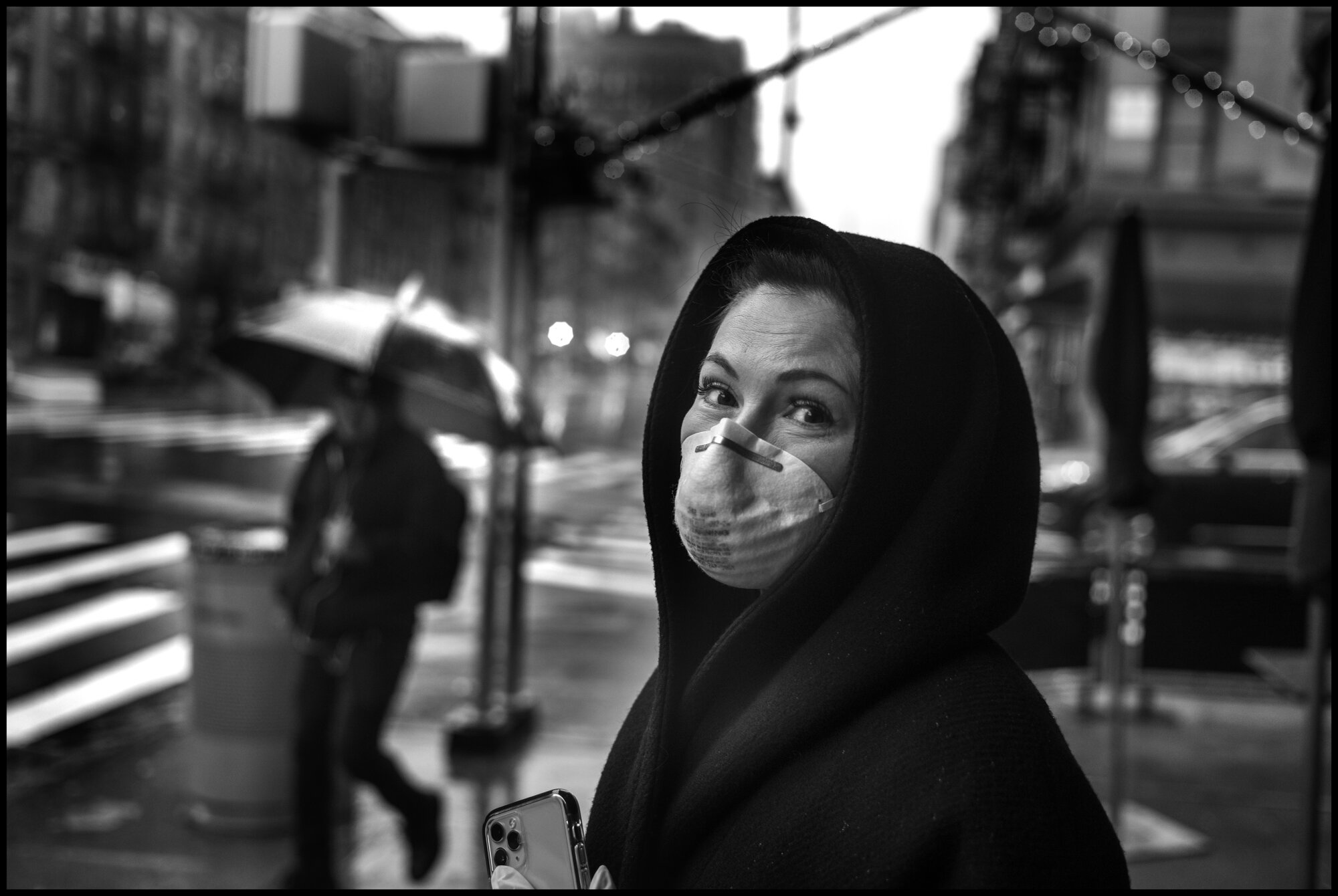  Natalia, originally from Odessa, in the Ukraine, stands on the sidewalk in the rain at 83rdand Columbus.  March 23, 2020. © Peter Turnley.  ID# 02-002 