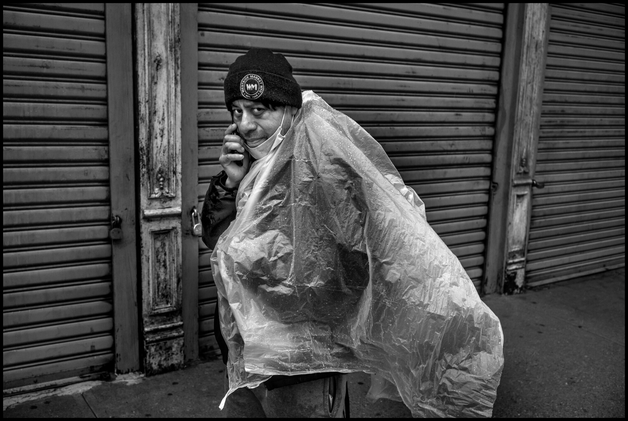  A delivery man, Jacinto, from Mexico, walks by during a rain storm on Amsterdam Ave.  March 23, 2020. © Peter Turnley.  ID# 02-003 