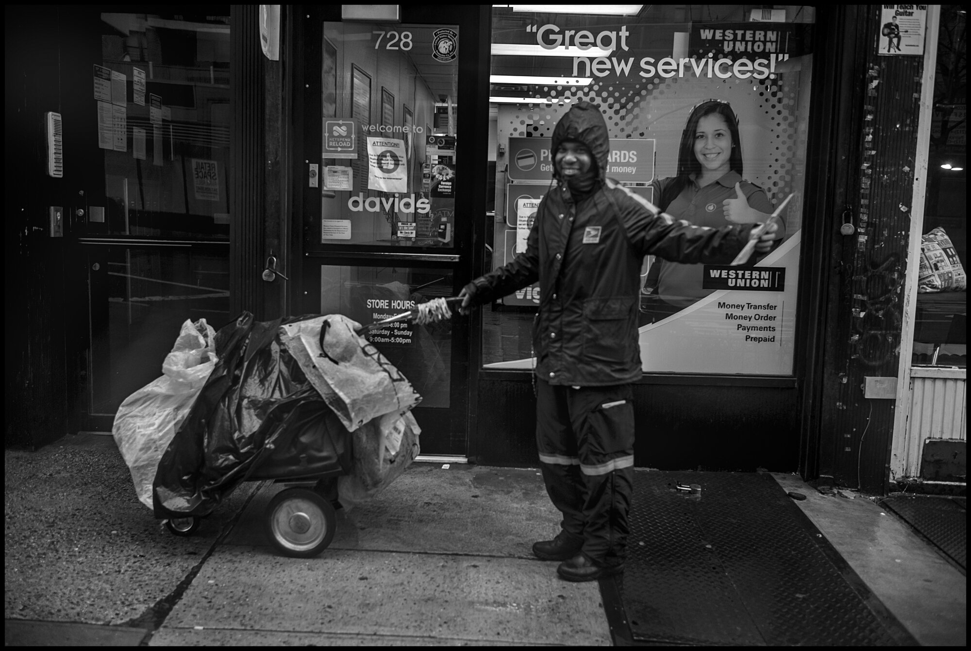  A postal worker, Jason, delivers the mail in a hard rain storm in the 90’s on Amsterdam. I asked him if he was scared to work at this time ,and he told me, “I’m not scared at all.”.  March 23, 2020. © Peter Turnley.  ID# 02-009 