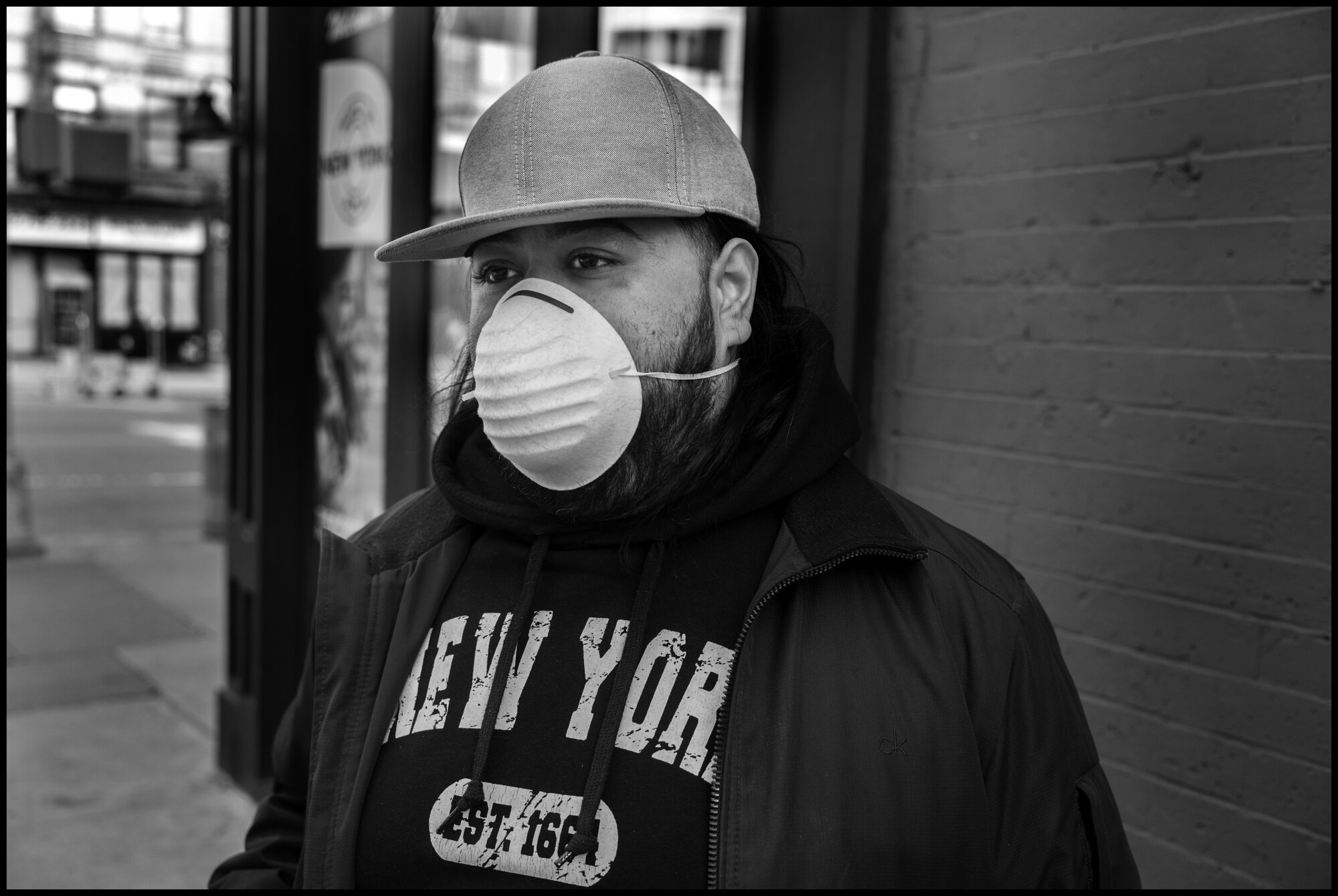  A young man prepares to take out the garbage on the sidewalk for a building on W. 80thStreet.  March 23, 2020. © Peter Turnley.  ID# 02-013 