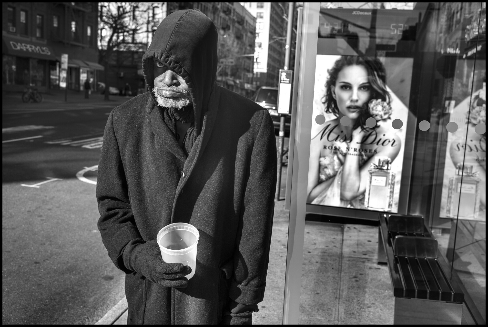  Clifford Jordan, 61, stands at bus stop on Amsterdam near where he lives. He told me he was out because he needs money to eat.  March 24, 2020. © Peter Turnley.  ID# 03-002 