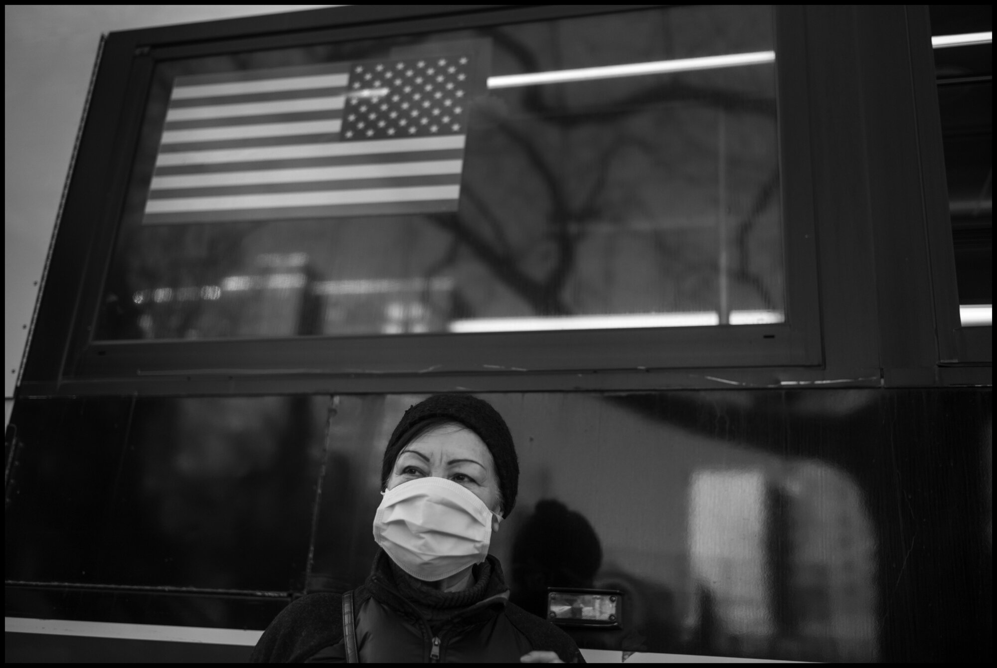  Rosario from Guatemala, stands in front of a public bus on Amsterdam Ave. on the Upper Westside.  March 24, 2020. © Peter Turnley.  ID# 03-007 