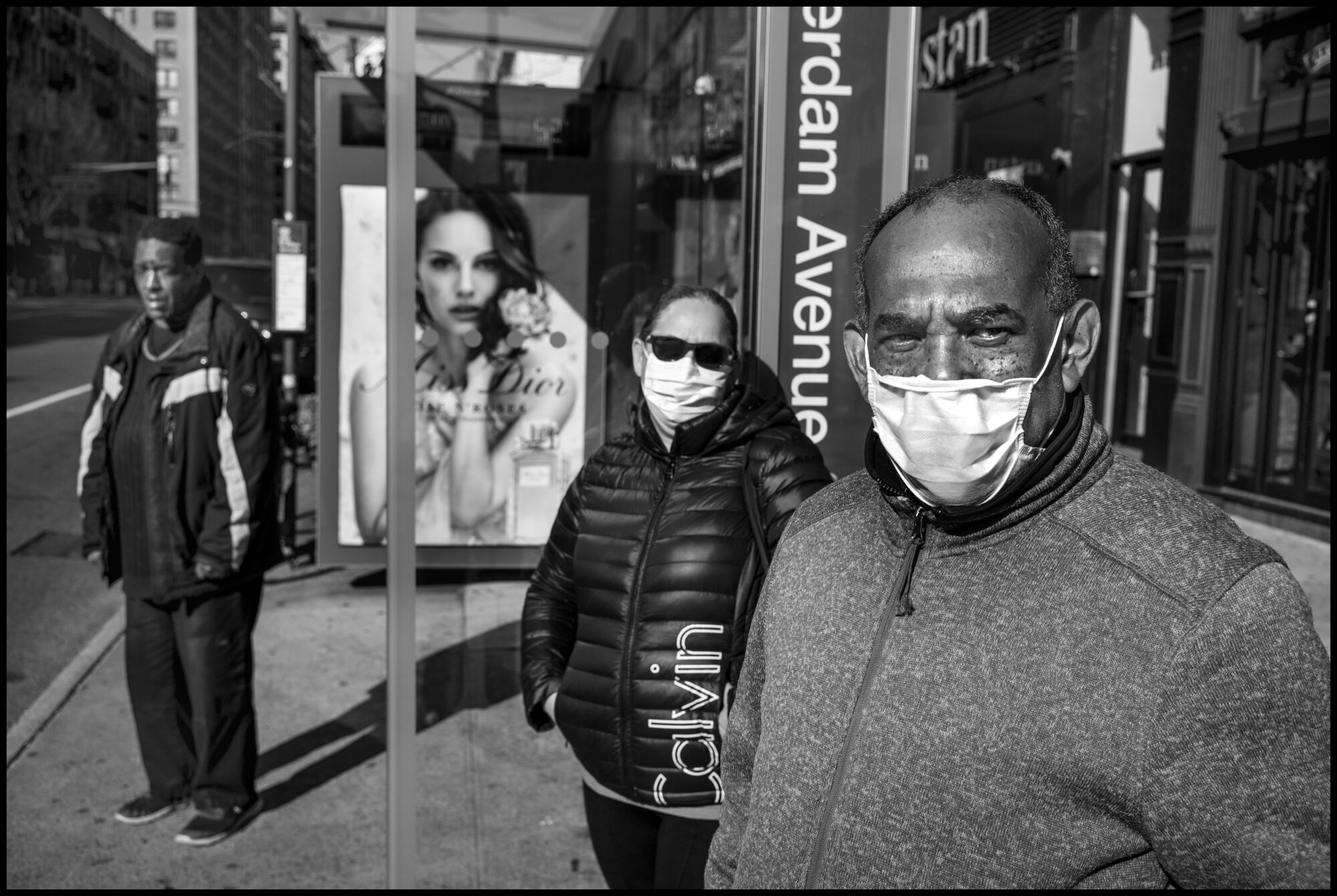  Luis and Eugenia, stand with protective masks at a bus stop on Amsterdam Ave.  March 24, 2020. © Peter Turnley.  ID# 03-008 