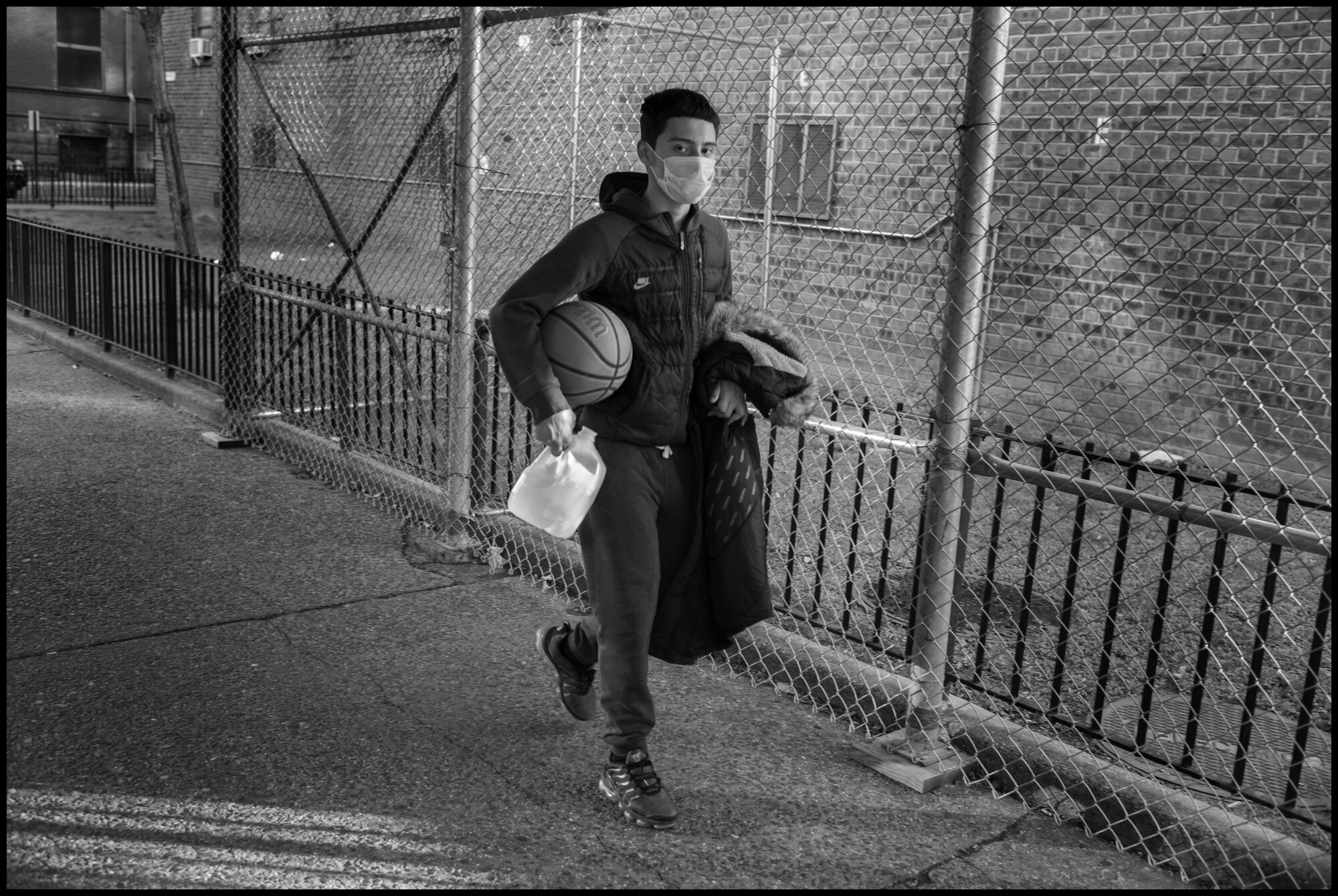  Rummy, returns alone from shooting baskets, wearing his protective mask, on Amsterdam Ave. on the Upper Westside.  March 24, 2020. © Peter Turnley.  ID# 03-011 