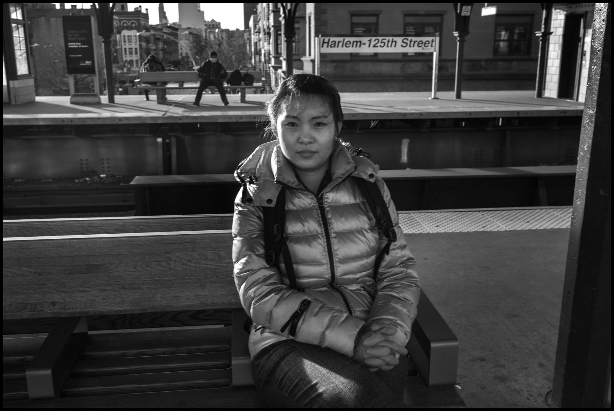  A medical student, Haymar, 29, from Myanmar, waits for a train to go home at the 125th street train stop in Harlem. She works at a medical clinic in Harlem.  March 24, 2020. © Peter Turnley.  ID# 03-013 