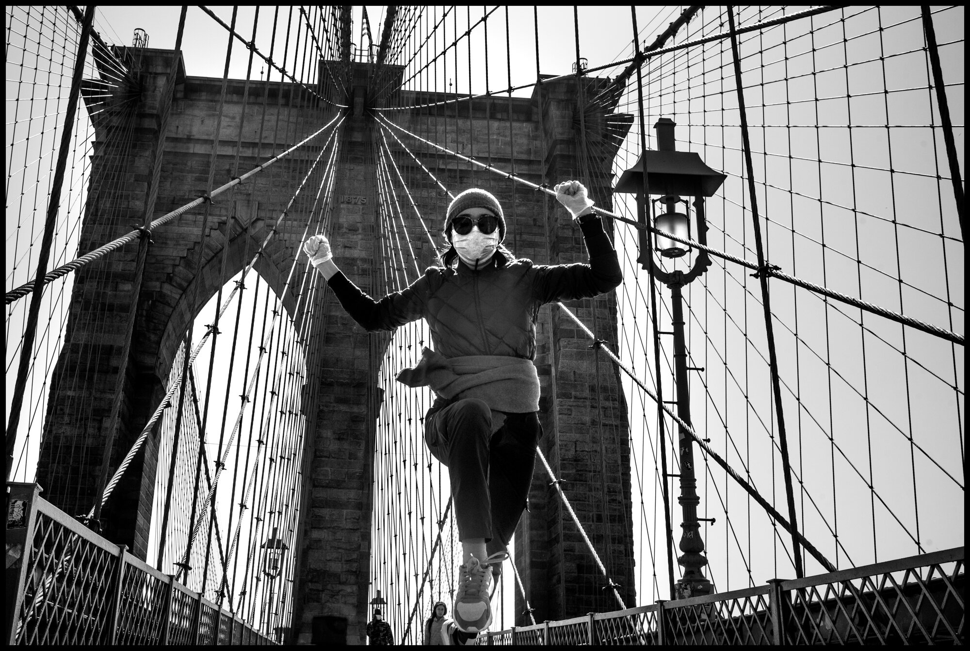  Yanan, a 30 year old woman from Wuhan, China, living in New York, goes out for a jog across the Brooklyn Bridge.  March 26, 2020 ©Peter Turnley  ID# 04-001 