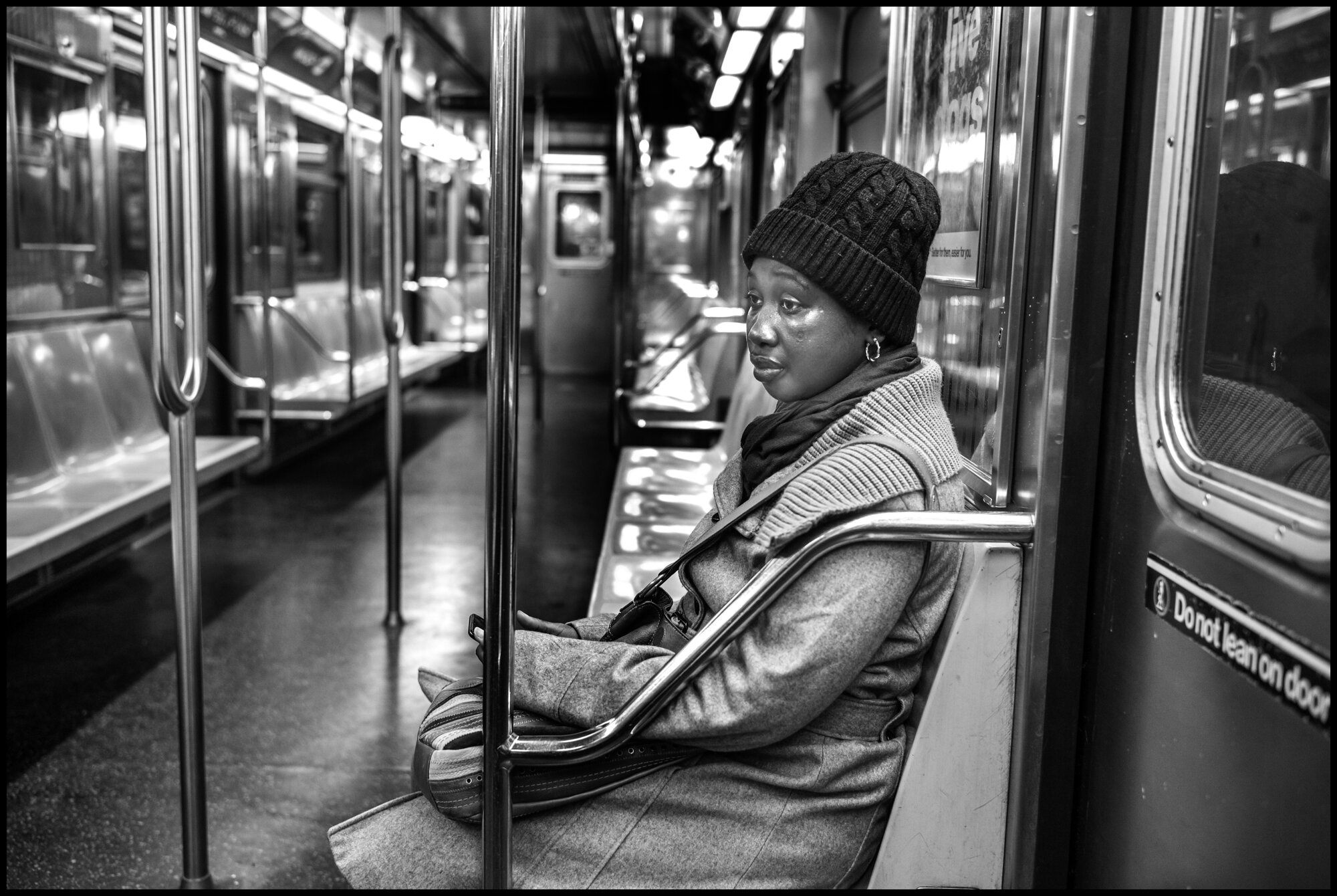  Sandra, 30, from W. Africa, rides the #1 train south alone as the only passenger in this subway car.  March 26, 2020 ©Peter Turnley  ID# 04-005 