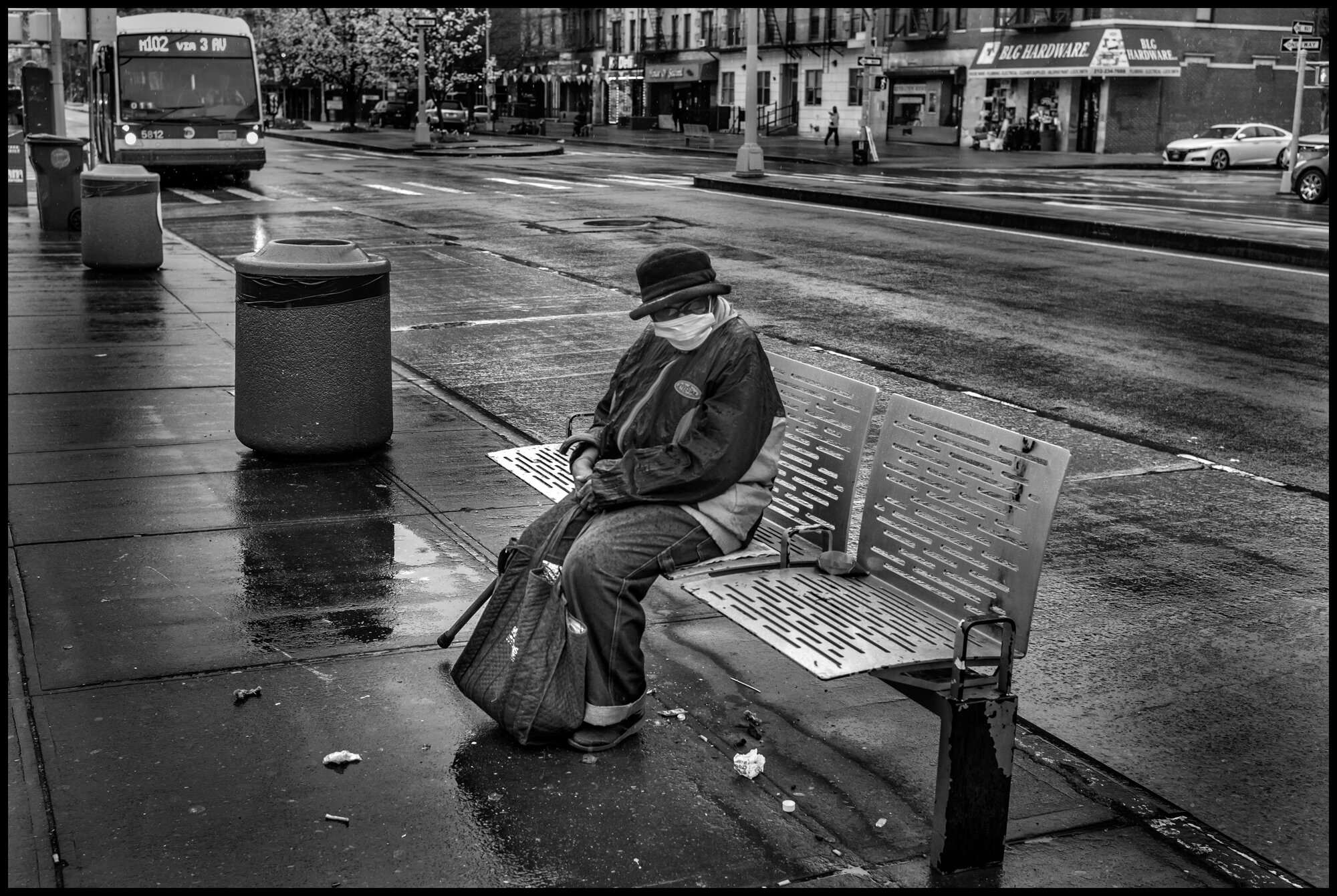  Lone elder woman named Mary, sitting on a bench in the rain at a place only yards from where I lived at 133rd and Lenox in the center of Harlem.   March 28, 2020. © Peter Turnley.  ID# 06-001 