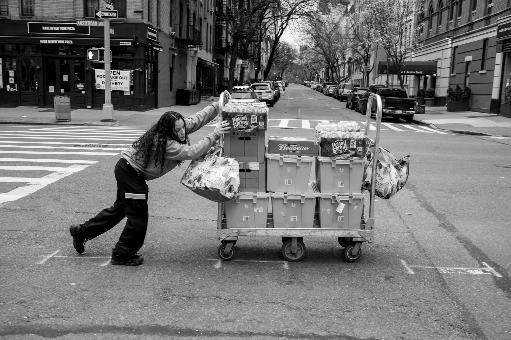  A woman delivers packages to a local store on the Upper Westside on Amsterdam Ave.  March 28, 2020. © Peter Turnley.  ID# 06-013 