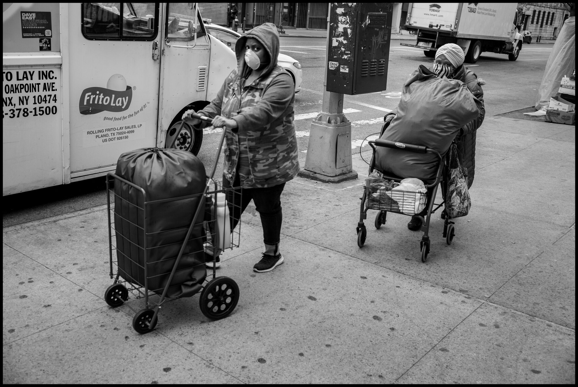  Women return from the laundry on 125th Street in Harlem.   March 28, 2020. © Peter Turnley.  ID# 06-009 