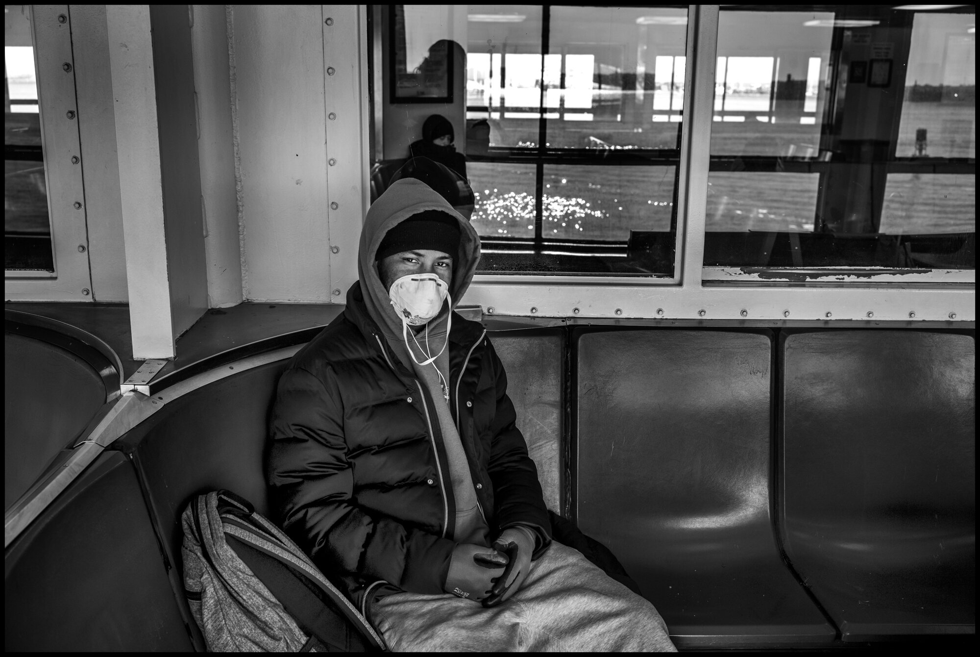  A young man takes the Staten Island Ferry towards Manhattan.  March 24, 2020. © Peter Turnley  ID#&nbsp;14-007 