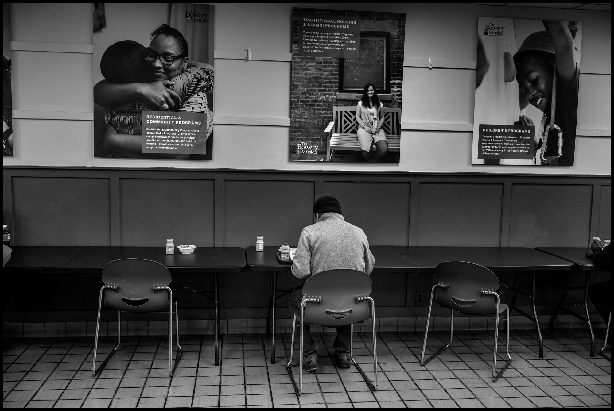  A man, without shelter, temporarily living at The Bowery, eats a hot noon meal.  April 10, 2020. © Peter Turnley  ID# 18-012 