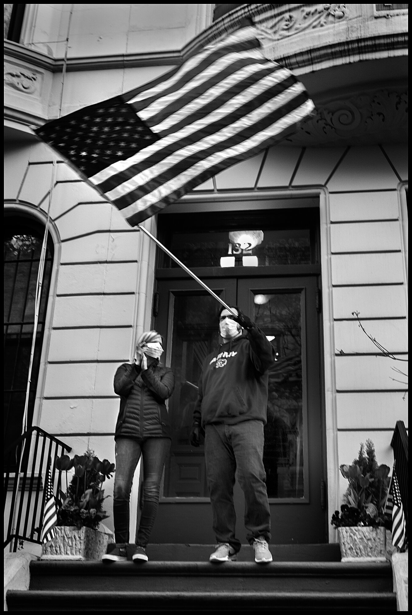  Gentleman waving a big American flag, as he does each night now during this collective 7pm expression of gratitude for all of the health workers and essential workers.  April 12, 2020. © Peter Turnley  ID# 19-005 