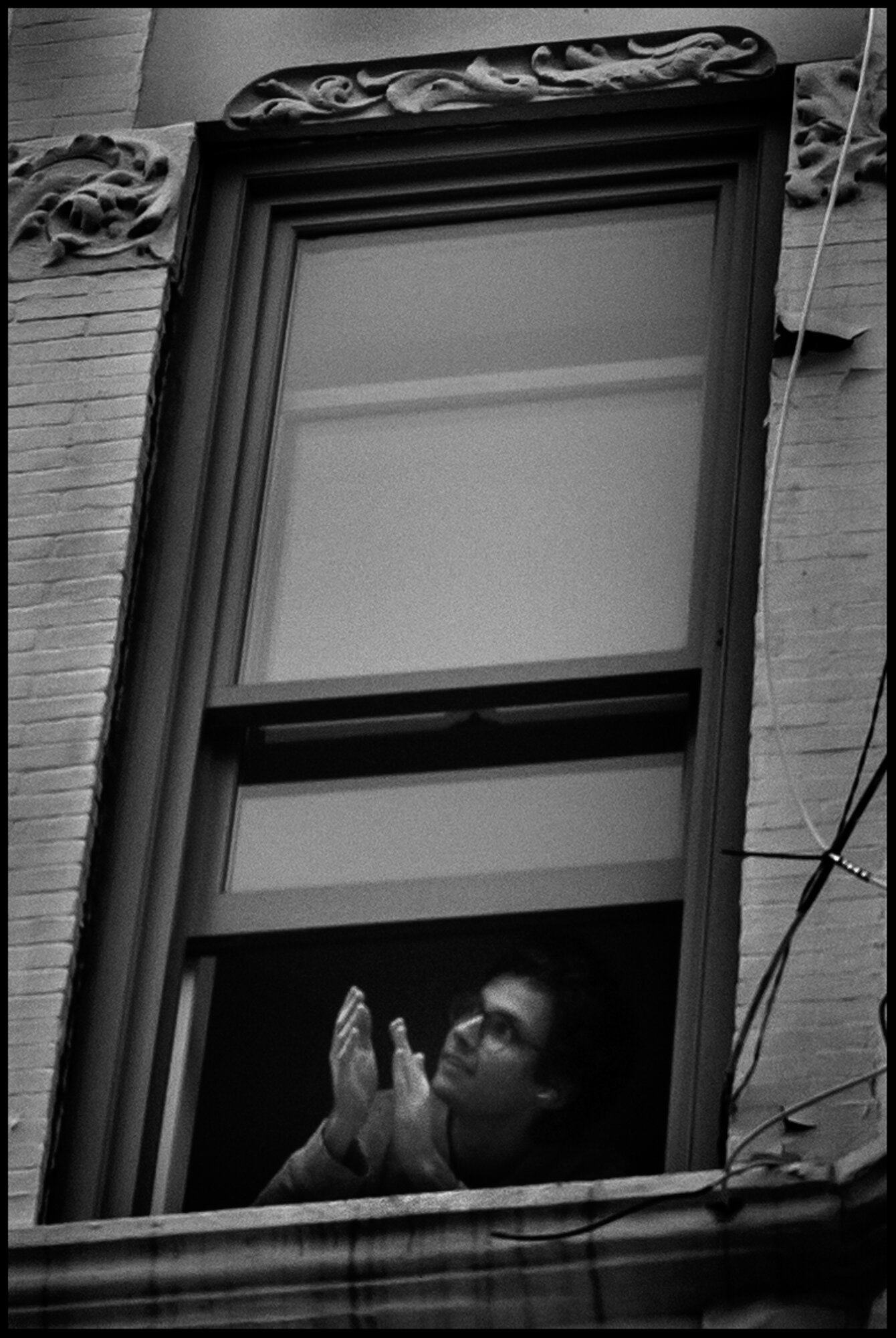  A resident of the Upper Westside claps and expresses her gratitude for all of the healthcare and essential workers. This takes place every evening at 7pm.   April 16, 2020. © Peter Turnley   ID# 22-005 