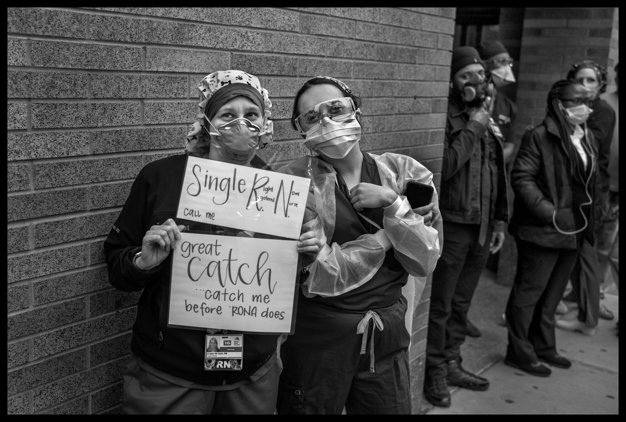  Two nurses from Mount Sinai Hospital who are currently working with Covid-19 patients, stand in front of the hospital at 7pm with a sign saying, “Single, Great Catch, catch me before Rona does”, as firemen with FDNY 43 Truck “El Barrio’s Bravest” st