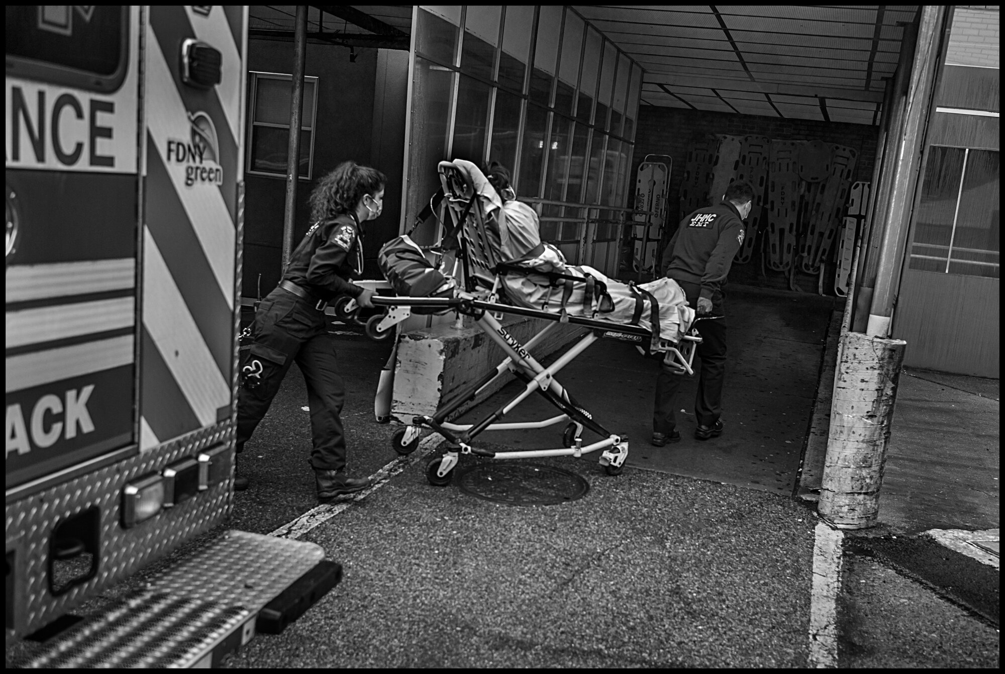  Ambulance workers take a patient into the emergency room at Elmhurst Hospital in Queens.  March 29, 2020. © Peter Turnley   ID# 07-002 