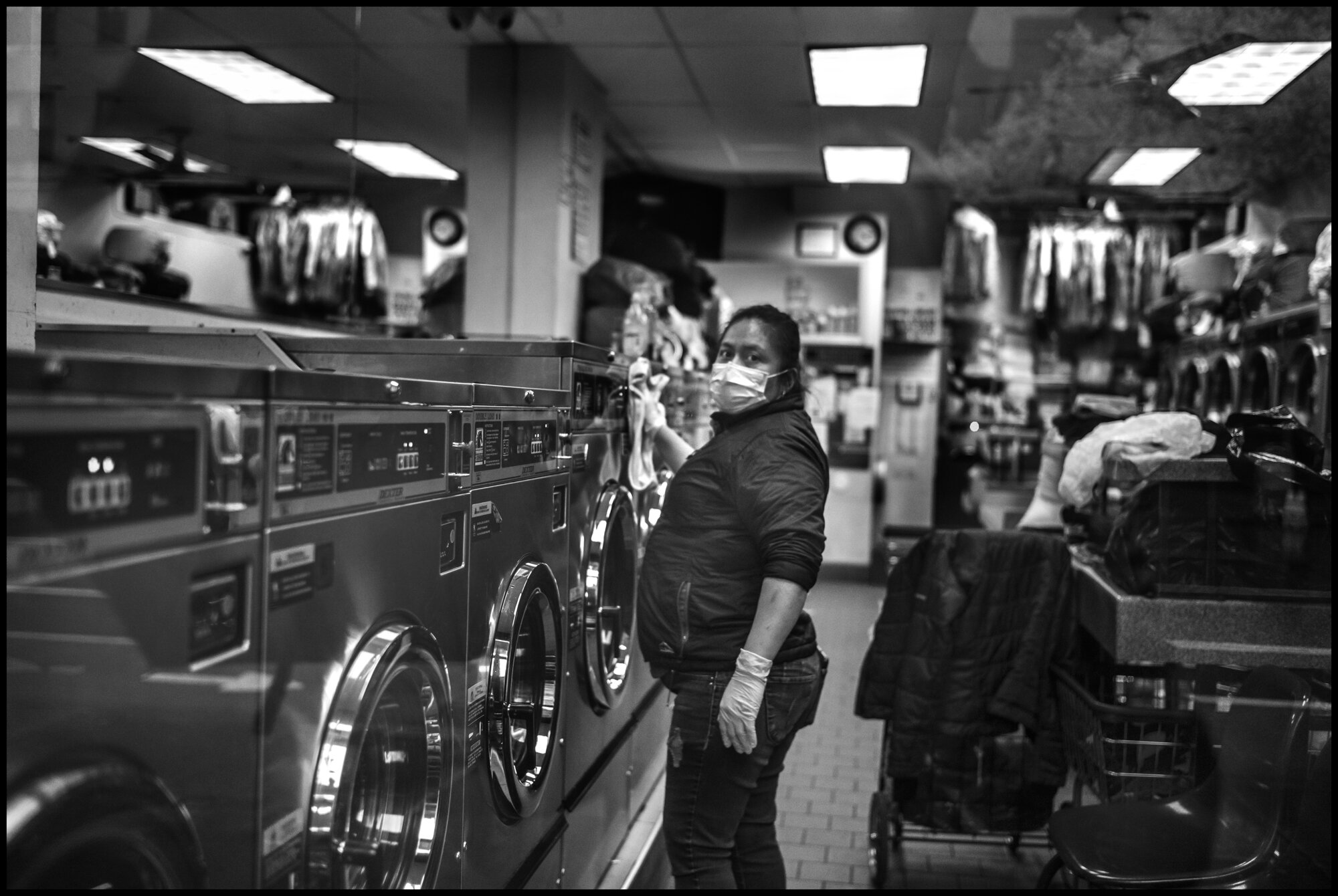  A laundry worker washes clothes at a shop on Amsterdam Avenue.  March 23, 2020. © Peter Turnley.  ID# 02-006 