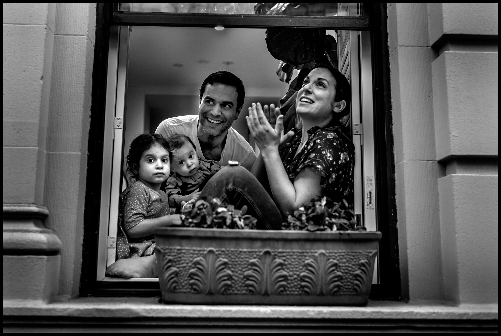  Tonight I went out for groceries and as I walked down my street on the Upper Westside, I saw a beautiful young family sitting in their windowsill. I stopped and introduced myself and told them I was their neighbor and asked if I could make a photogr