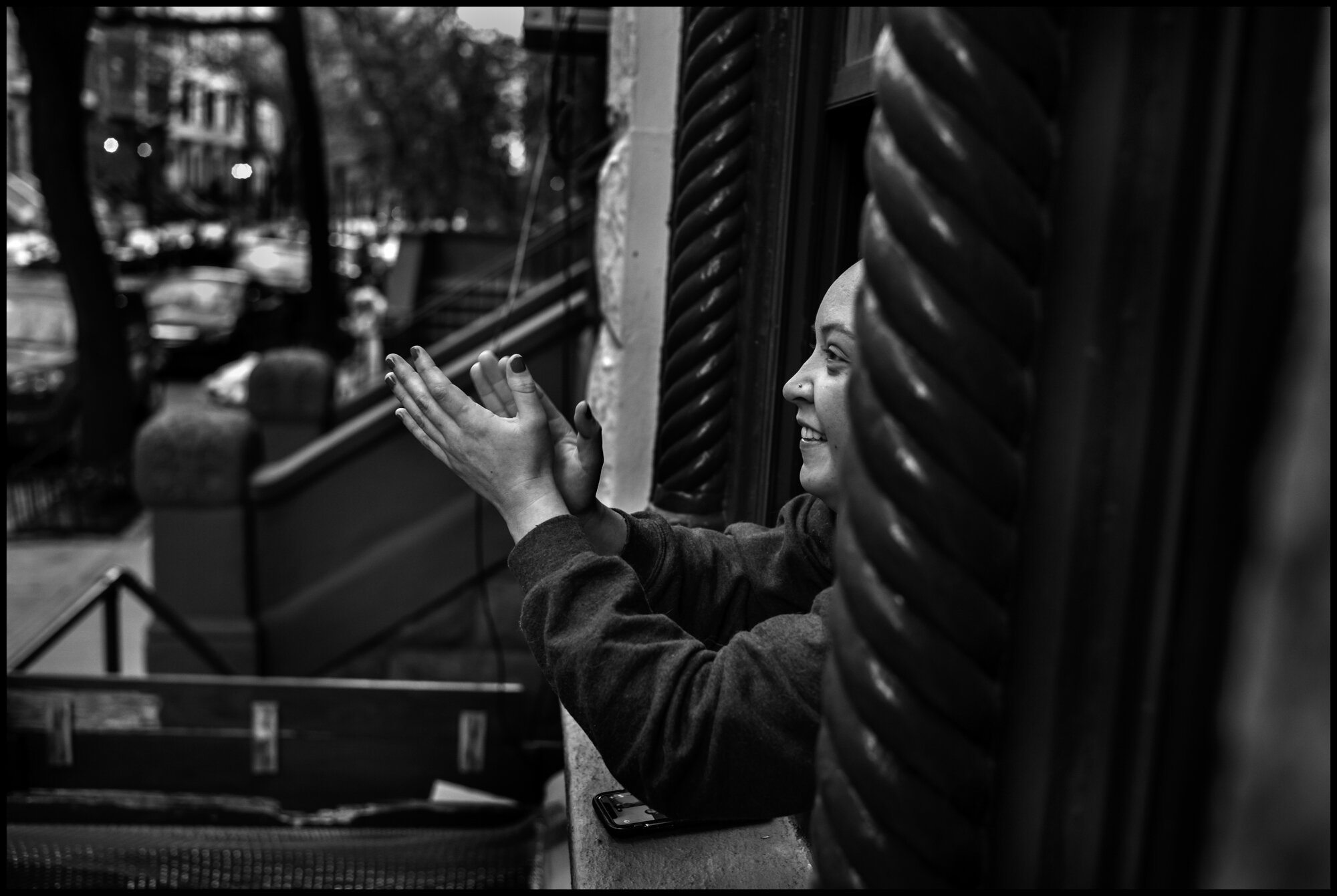  Jamie, a resident of the Upper Westside, claps and expresses her gratitude for all of the healthcare and essential workers. This takes place every evening at 7pm.   April 16, 2020. © Peter Turnley.   ID# 22-002 