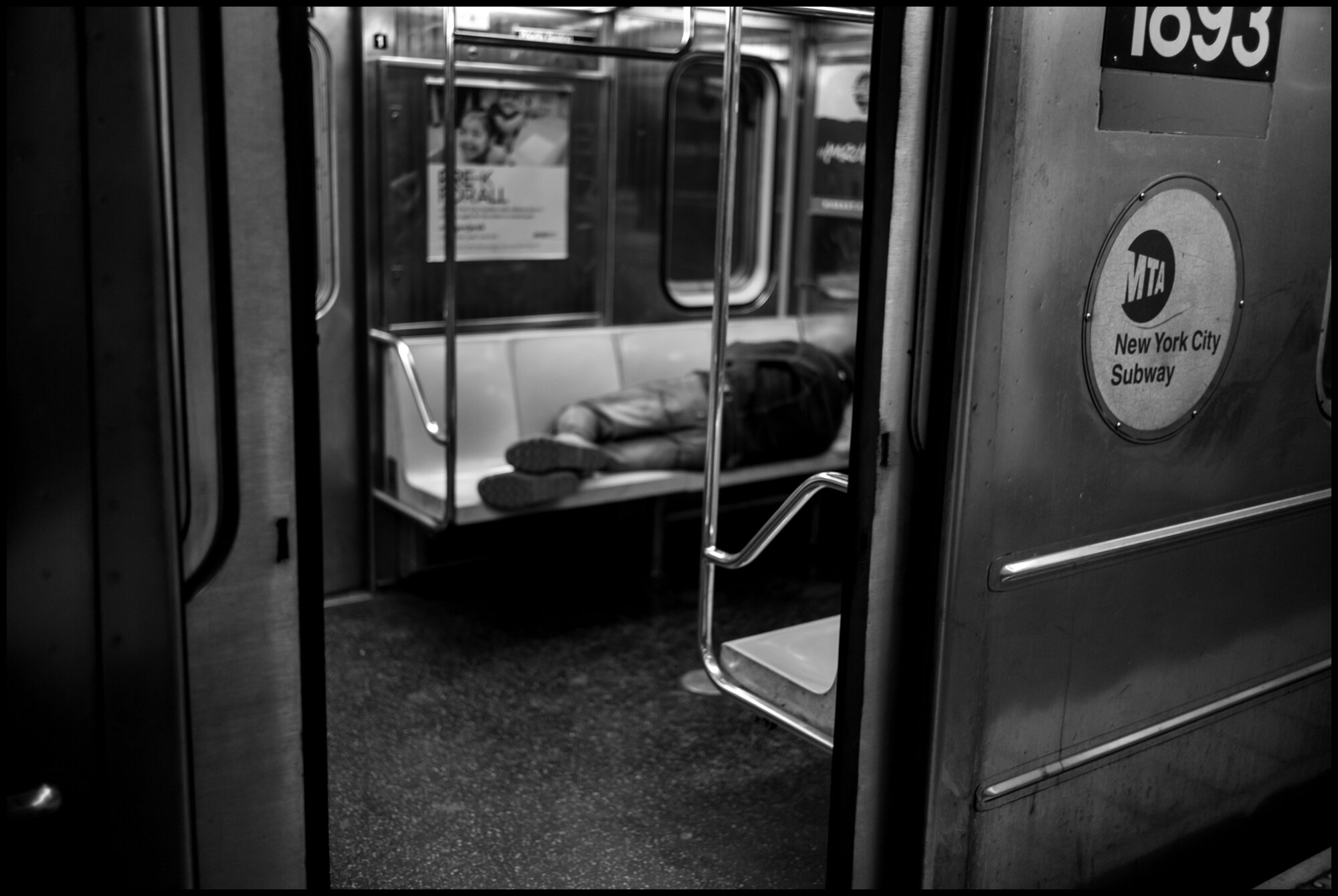  A homeless man finds shelter for sleep on a train at the Times Square Station.   March 20, 2020. © Peter Turnley.   ID# 01-014 