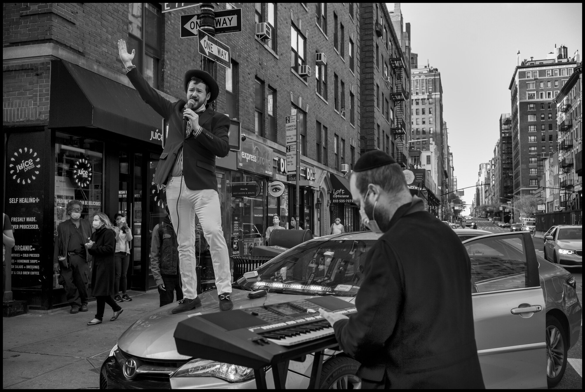  Young man sings from atop a car, “America the Beautiful”, at 7pm on Mother’s Day.  May 10, 2020. © Peter Turnley.   ID# 42-010 