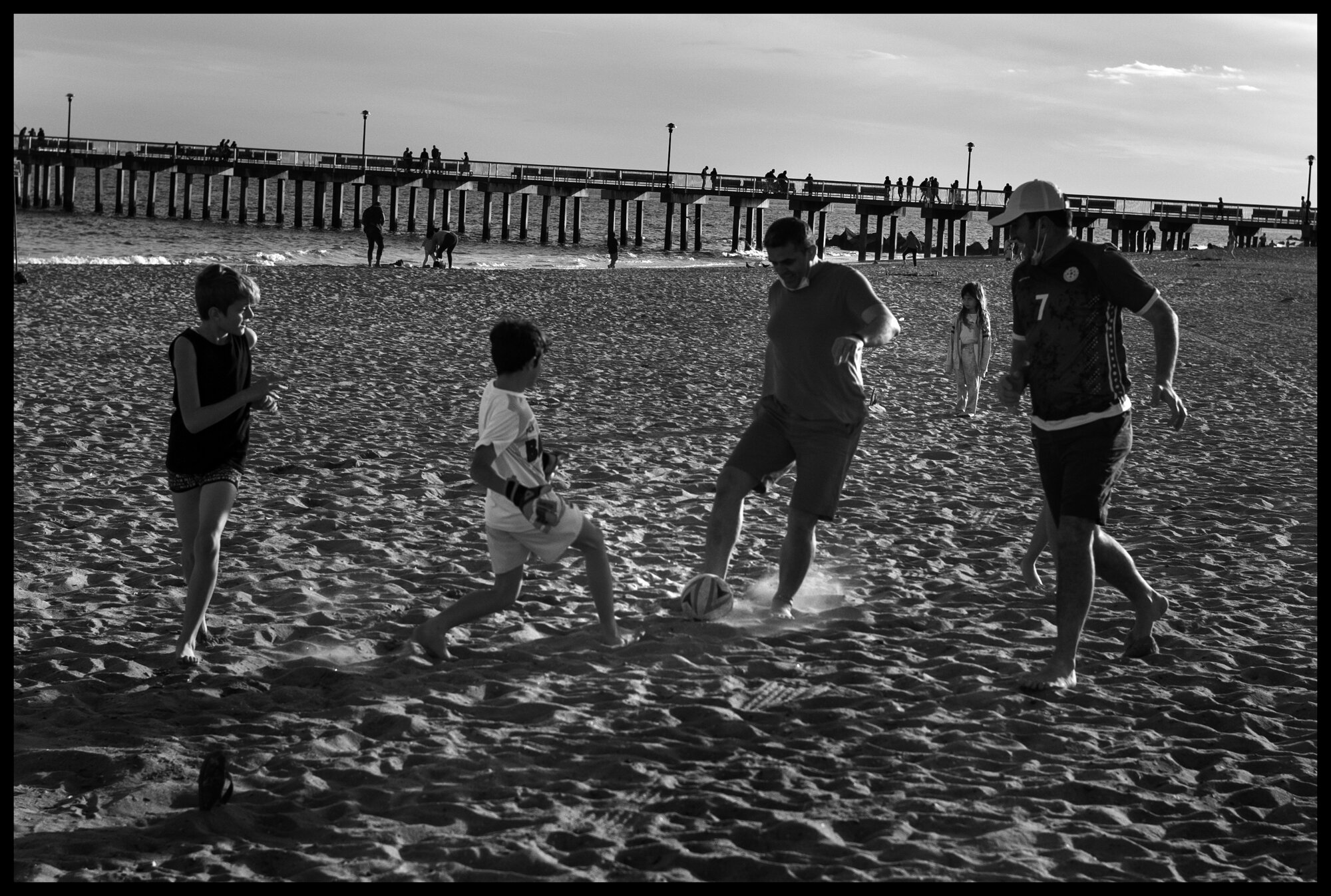  Two fathers play soccer with their sons. Coney Island. Coney Island, New York.  May 16, 2020. © Peter Turnley.  ID# 49-018 