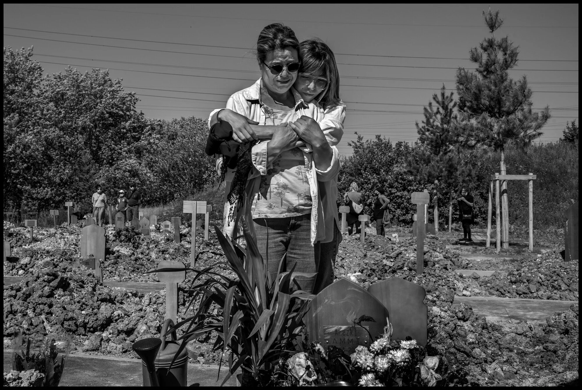  Hayat, 55, and Tidia, daughter, holding each other in tears honoring with grief and love, a husband, and father, Arezki Ammi, who passed recently from Covid-19. St. Denis, France.   May 29, 2020. © Peter Turnley.  ID# P08-001 